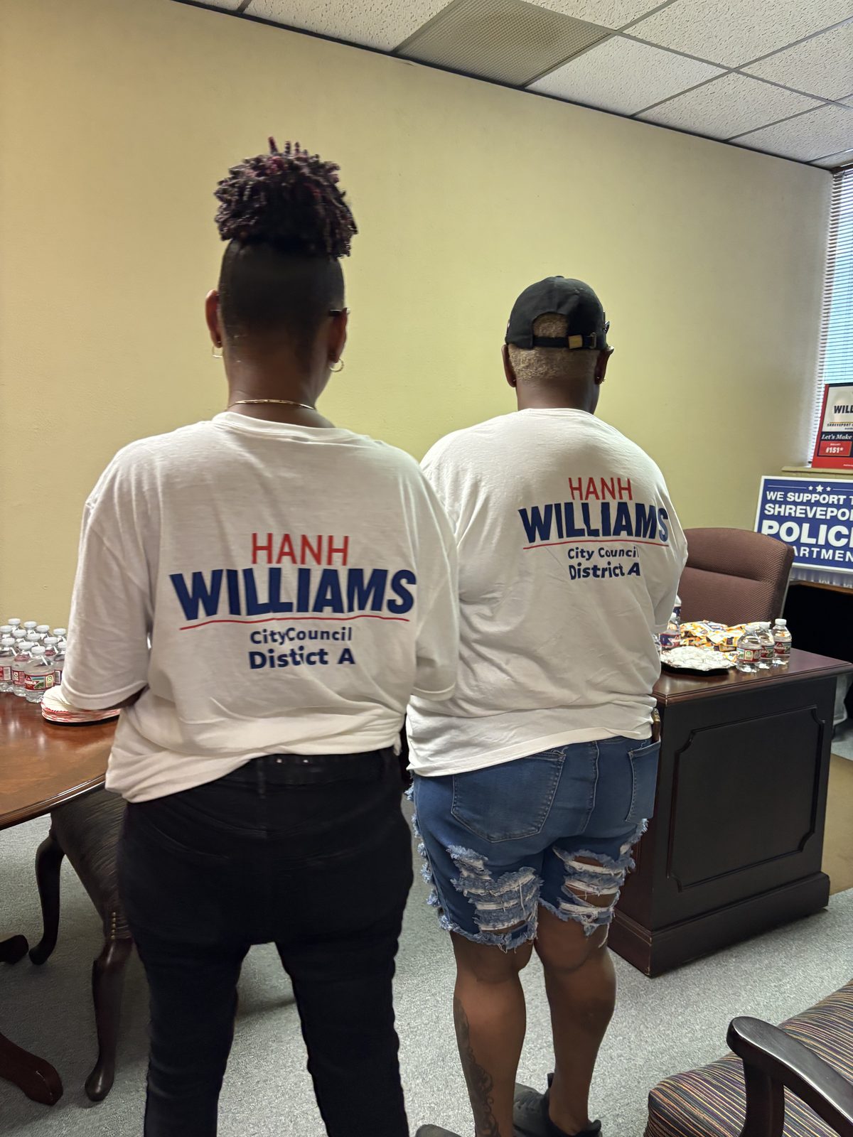 Two campaign volunteers seen from behind in white Hanh Williams City Council District A shirts at the campaign office, October 2, 2026